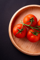 Tomato vegetables on wooden plate close up top view
