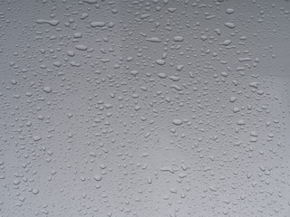 Transparent clean rain drops on the gray surface