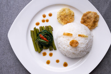 Fried morning glory with rice in gray bowl on table.