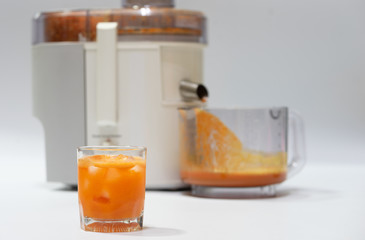Modern electric juicer  various fruit and glass of freshly made juice  healthy lifestyle concept