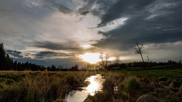 Dramatic sunset over prairie farmland, motion time lapse.