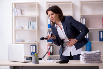 Middle-aged female employee suffering in the office 