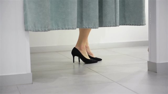 Woman Legs In Fitting Room In Mall. Shopping and Clothes Store Concept. Close Up View Of High Heeled Foots.