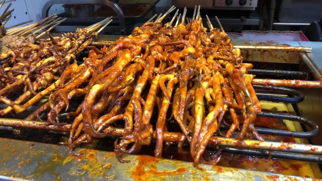 Fried and live scorpions in a Wangfujing street market in Beijing, diverse exotic street food. 