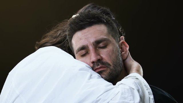 Jesus Christ hugging crying male parishioner, making satisfaction with sins
