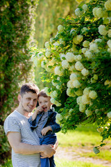 Obraz premium Young father and his smiling son in the park, hugging and enjoying time together, father's day celebration