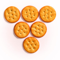 inverted triangle of six round crackers on white, in three rows, learning to count concept.
