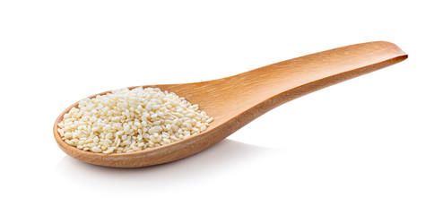 Sesame seeds in a wooden spoon isolated on white background