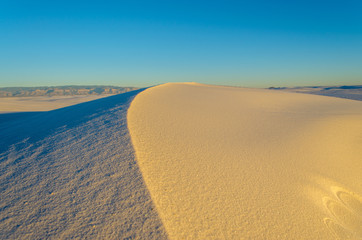 A Sand Dune in a Desert during Sunset