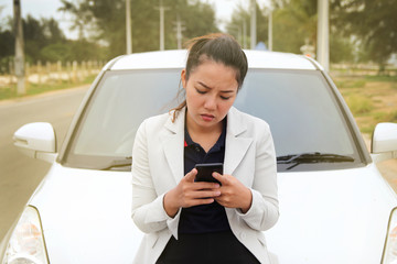 Woman business searching for phone contacts fore help from the broken car