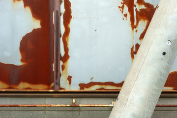 Rusted steel plate wall and telephone pole                              