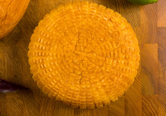 national Adyghe cheese homemade on a cutting Board with a knife, Basil, parsley, lime, sesame oil,...