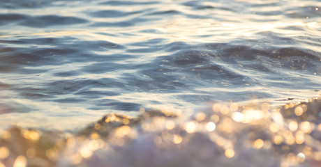 pebble stones on the sea beach, the rolling waves of the sea with foam