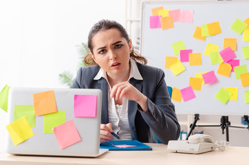 Young female employee in conflicting priorities concept 