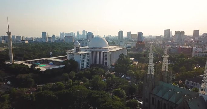 JAKARTA, Indonesia - May 14, 2019: Beautiful aerial view of Istiqlal Mosque from a drone flying forwards near Cathedral Church. Shot in 4k resolution