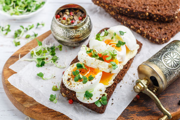 Rye bread sandwich with boiled egg, cheese, freshly ground pepper and daikon or radish sprouts. Delicious gourmet Breakfast. Selective focus