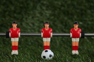 Red foosball plastic players. Soccer ball
