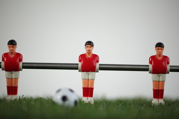 Red foosball plastic players. Soccer ball