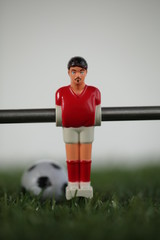 Red foosball plastic players. Soccer ball