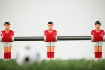 Red foosball plastic players. Soccer ball