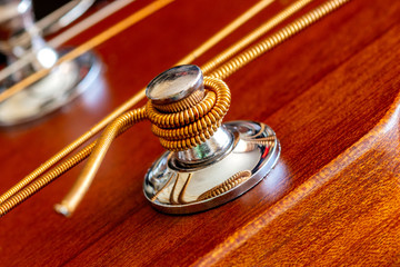 Fastening of a string on an acoustic guitar. Macro shooting