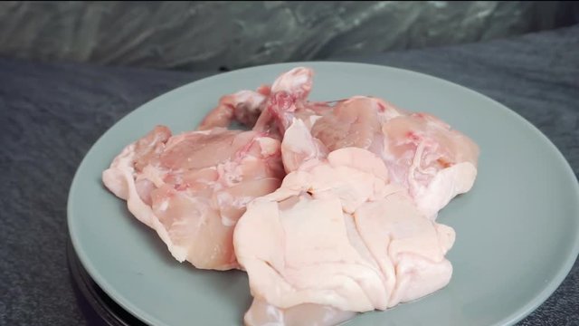 Raw chickhen legs on plate rotating