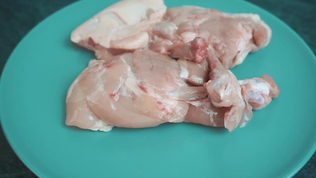 Raw chickhen legs on plate rotating