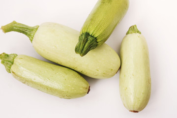 Courgettes arranged on a white background in random order, top view