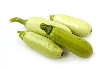 Courgettes arranged on a white background in random order, top view