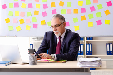 Aged man employee in conflicting priorities concept 