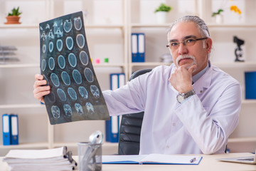 Aged male doctor radiologist in the clinic 