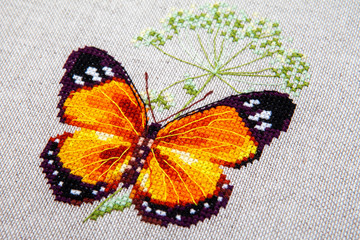 Obraz na płótnie Canvas Cross-stitch butterfly with pink wings.