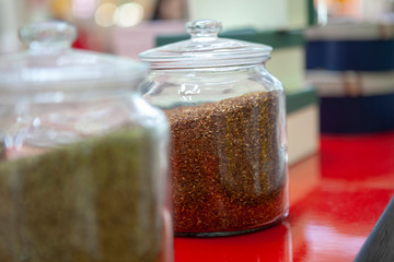 Tea blends in glass jars on the counter of the cafe. Bright colors of tea.