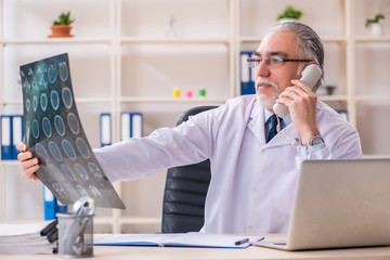 Aged male doctor radiologist in the clinic 