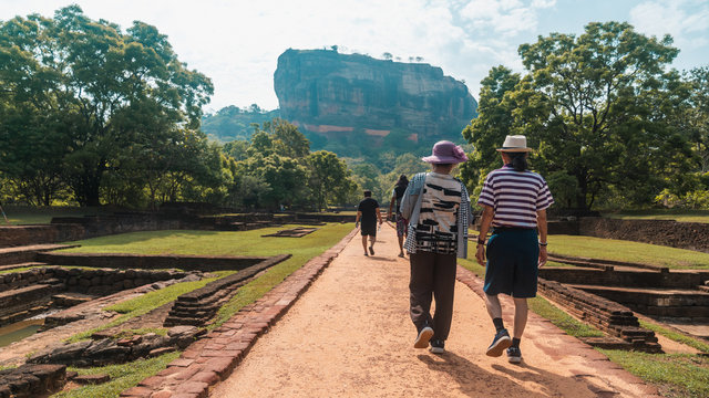 Senior old couple travellers walking up the road to Sigiriya Lion's Rock in Sri Lanka