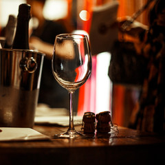 Wine tasting: an empty glass stands on the tasting table next to brochures, champagne corks and silver buckets in which the wines are cooled.