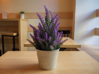 Beautiful violet lavender in a iron little bucket on the wooden table in the cafe