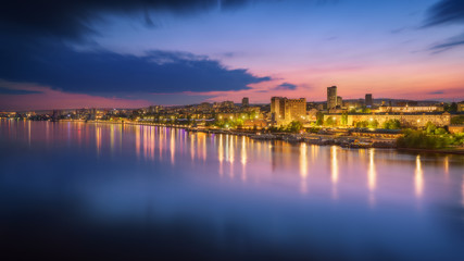 Fototapeta premium Saratov city skyline at sunset, panoramic view to quay from the bridge on Volga river. Russia
