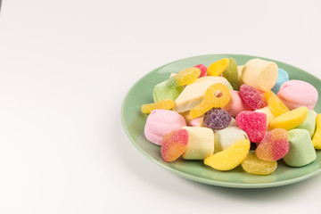 Plate with sweets isolated on a white background. Gummy candies and marshmallow.