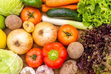 Vegetables on the dark background. Organic foods and fresh vegetables. Cucumber, cabbage,  salad, pepper,onion, garlic, carrot, lettuce and tomato on the table.
