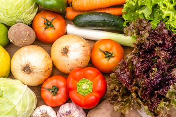 Vegetables on the dark background. Organic foods and fresh vegetables. Cucumber, cabbage,  salad, pepper,onion, garlic, carrot, lettuce and tomato on the table.
