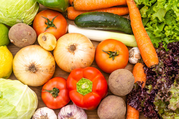 Vegetables on the dark background. Organic foods and fresh vegetables. Cucumber, cabbage,  salad, pepper,onion, garlic, carrot, lettuce and tomato on the table.