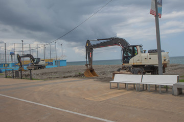 Fototapeta premium Equipment, excavator on duty at sea beach shore to renovate and relocation prepare for development
