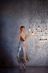 Fashion portrait of a young woman in a glass dress. Fashion and glamour.