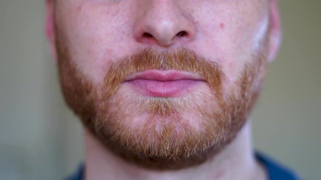 Super close up young caucasian man eating a pizza slice and chewing