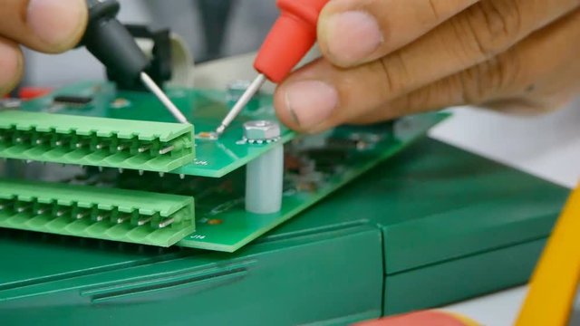 Hand close up of Electrical engineer to check Electric Part on work desk