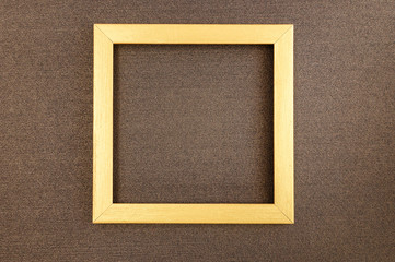 Golden square frame on brown mother-of-pearl designer cardboard.