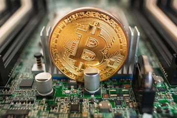 Bitcoin close-up on a computer circuit motherboard as a blockchain technology payment network. Digital cryptocurrency concept and mining.