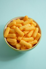 Cheese flavored puffed corn snacks
