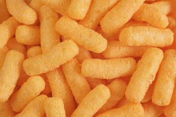 Cheese flavored puffed corn snacks